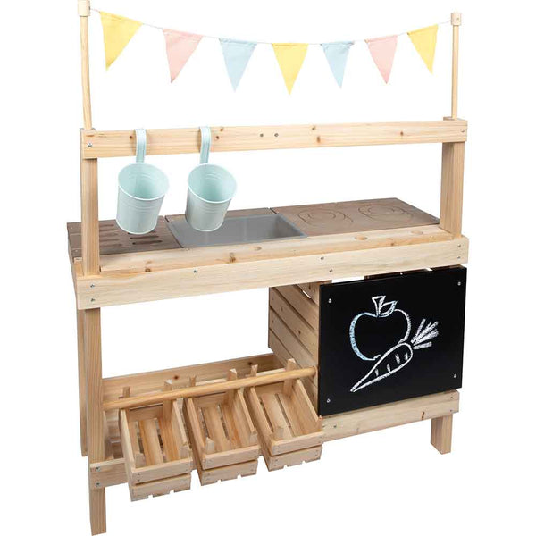 Eine hölzerne Spielküche mit hängenden Fahnen, zwei Metalleimer, eine Kreidetafel mit Obst- und Gemüsezeichnungen und drei hölzerne Vorratskisten.