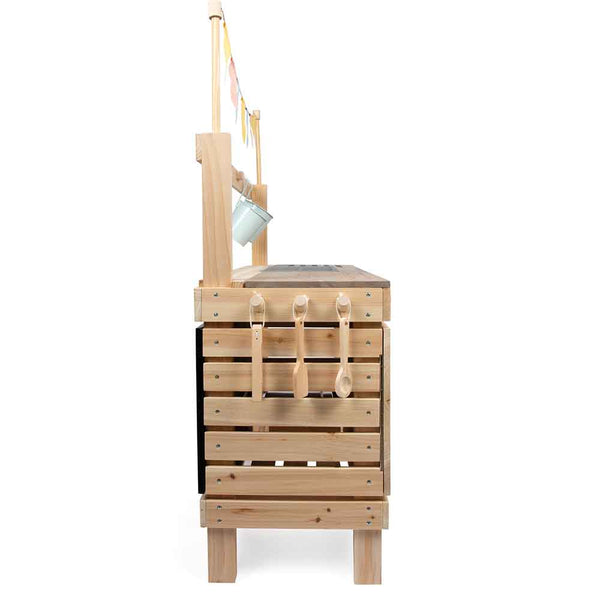 Seitenansicht einer Spielküche aus Holz mit hängenden Utensilien und einem kleinen Eimer, der an der Rückwand befestigt ist.