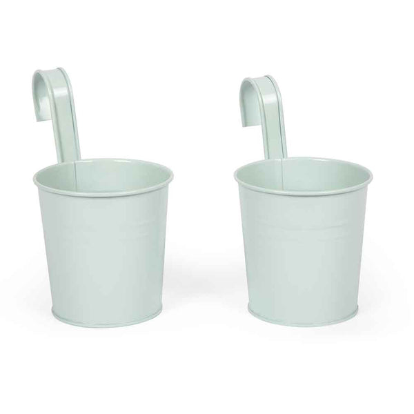 Zwei hellgrüne Hängetöpfe aus Metall mit geschwungenen Haken an den Rändern, zum Aufhängen an Geländern oder Zäunen.