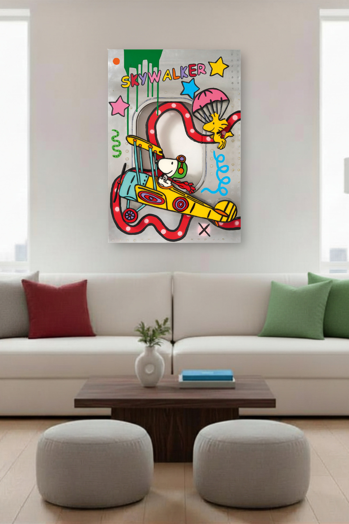 Ein Kunstwerk zeigt Snoopy, wie er in einem farbenfrohen Flugzeug mit der Aufschrift SKYWALKER fliegt, während Woodstock in der Nähe mit einem Fallschirm abspringt. Leuchtende Sterne und Wirbel vor einem metallisch schimmernden Hintergrund vervollständigen das Motiv. Das Bild hängt in einem Wohnzimmer.