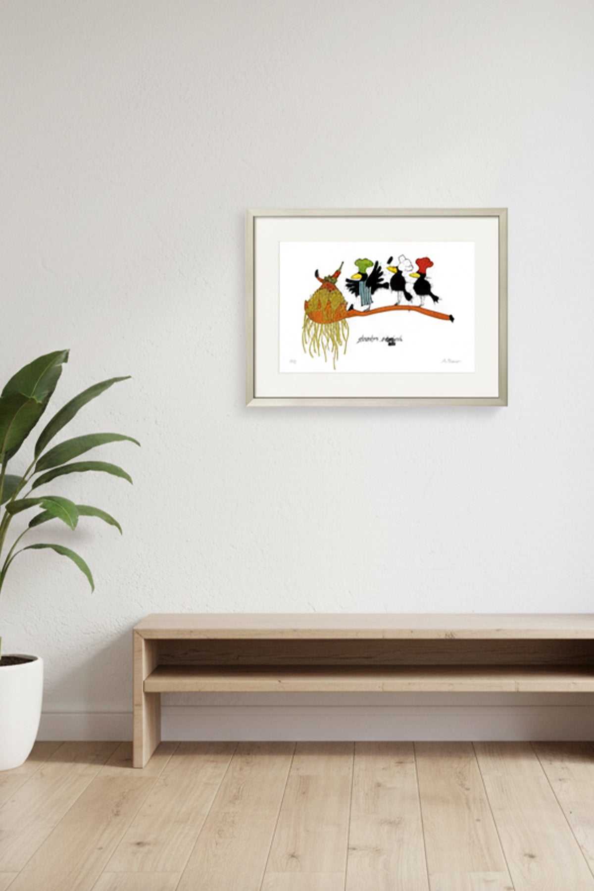 Ein gerahmter Kunstdruck hängt an einer weißen Wand über einer Holzbank; links davon steht eine Topfpflanze auf einem hellen Holzboden.