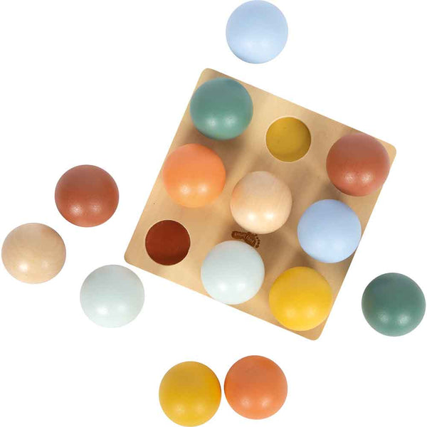 Ein Holzbrett mit kreisförmigen Löchern und zwölf farbigen Holzkugeln, die um das Brett herum angeordnet sind.