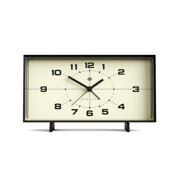 Rechteckige, schwarz gerahmte Uhr mit schwarzen Zahlen und Zeigern, die die Uhrzeit 10:10 anzeigen.
