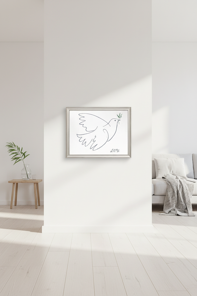 Minimalistisches Wohnzimmer mit weißen Wänden, hellem Holzboden, einem kleinen Tisch mit einer Pflanze, einem grauen Sofa mit einer Decke und einer gerahmten Strichzeichnung einer Taube, die einen Olivenzweig hält.