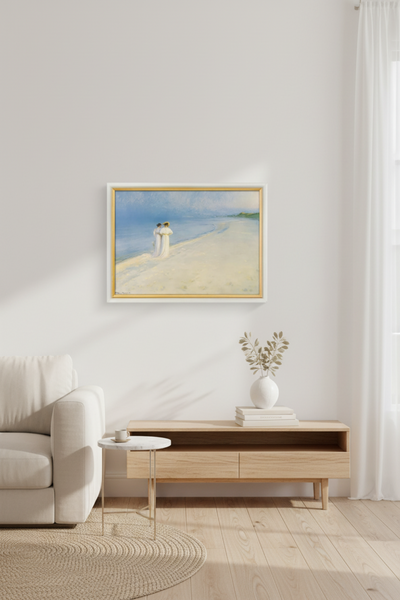 Ein minimalistisches Wohnzimmer mit einem weißen Sofa, einem kleinen runden Tisch und einer Holzkonsole unter einem gerahmten Strandbild an einer weißen Wand. Licht fällt durch ein Fenster mit weißen Vorhängen ein.