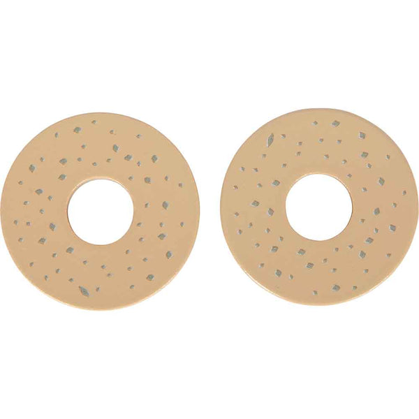 Zwei runde, beigefarbene Objekte mit zentralen Löchern und kleinen, verstreuten grauen Flecken, die nebeneinander auf weißem Hintergrund angeordnet sind.