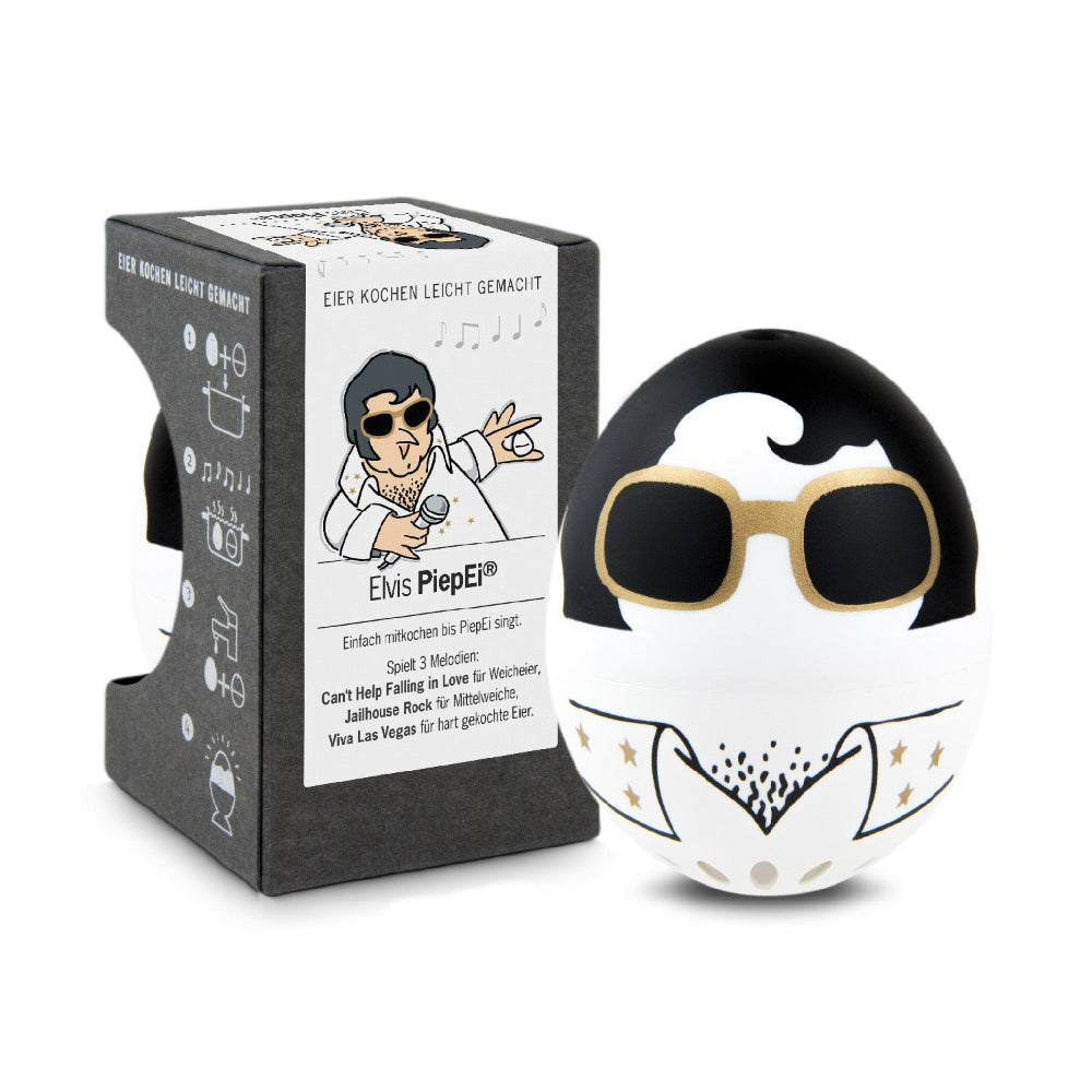 Eine Eieruhr in Form eines Eies mit einem Elvis-Presley-Motiv steht neben der Verpackung, die mit passenden Grafiken und Texten versehen ist.