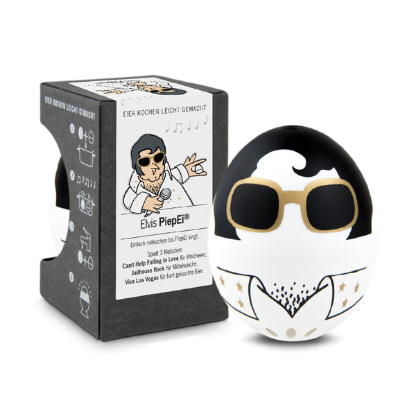 Eine Eieruhr in Form eines Eies mit einem Elvis-Presley-Motiv steht neben der Verpackung, die mit passenden Grafiken und Texten versehen ist.