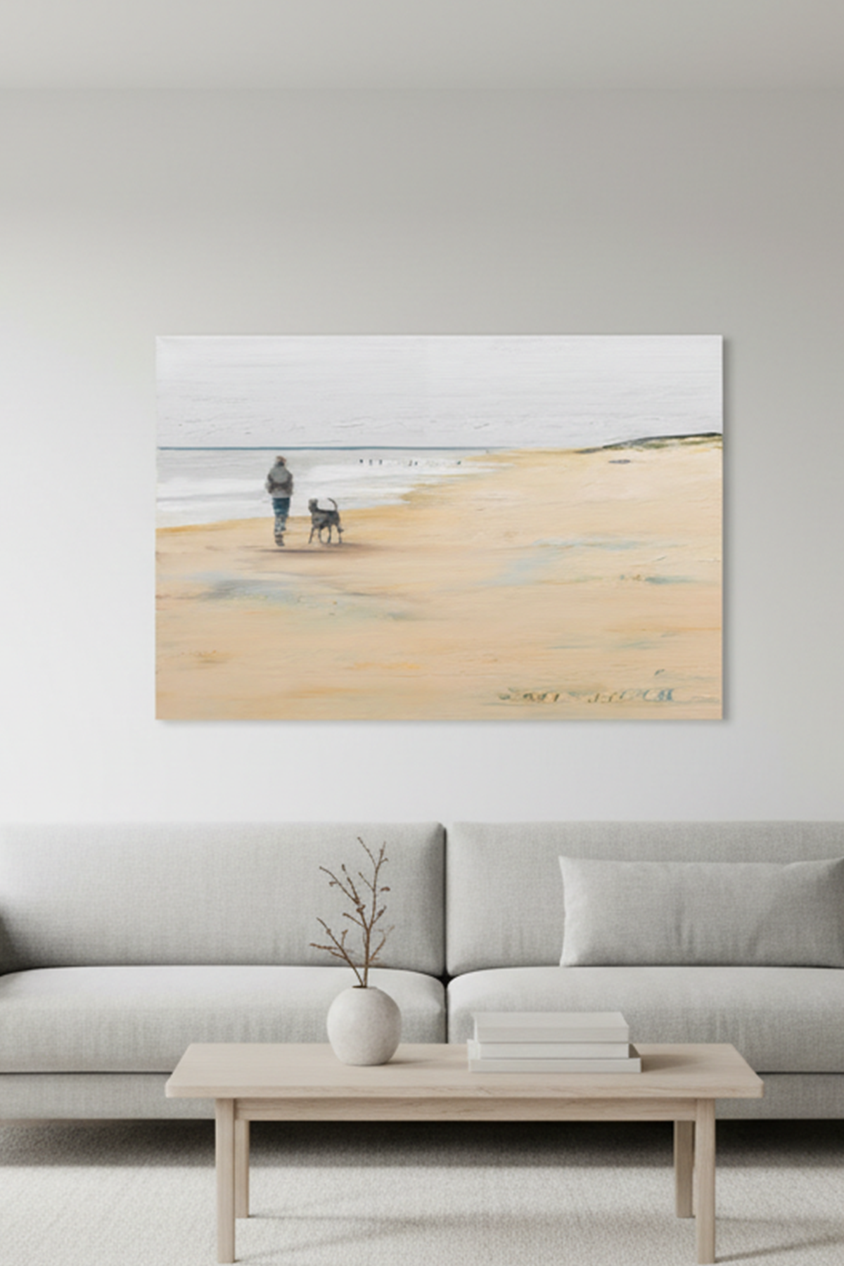 Das Gemälde mit einer Person und ein Hund gehen unter einem bewölkten Himmel an einem ruhigen Sandstrand entlang - platziert in einem Wohnraum an der Wand hängend. 