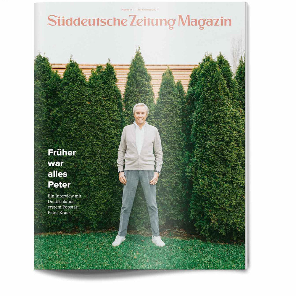 Auf dem Titelbild des Süddeutsche Zeitung Magazins steht ein lächelnder Mann vor hohen grünen Bäumen.