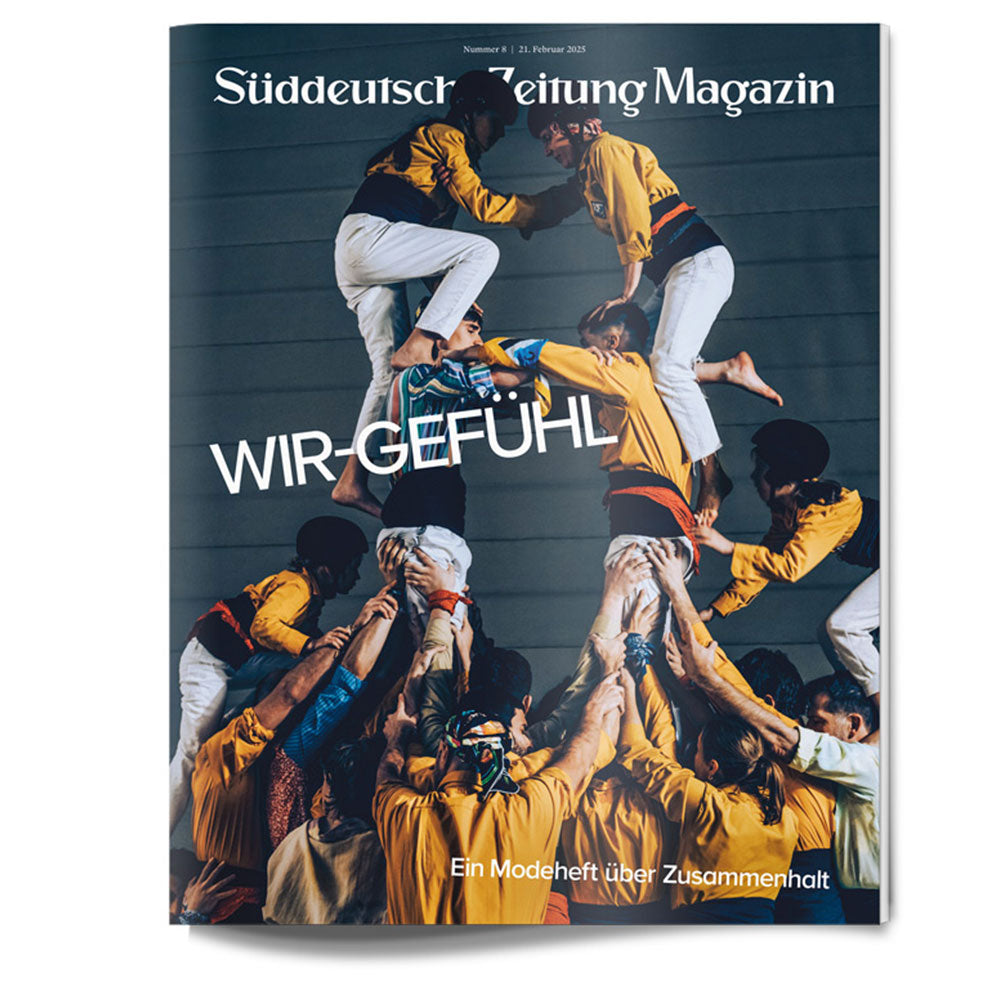 Eine Gruppe von Menschen in Gelb und Orange bildet eine menschliche Pyramide auf dem Titelbild der Zeitschrift WIR-GEFÜHL.