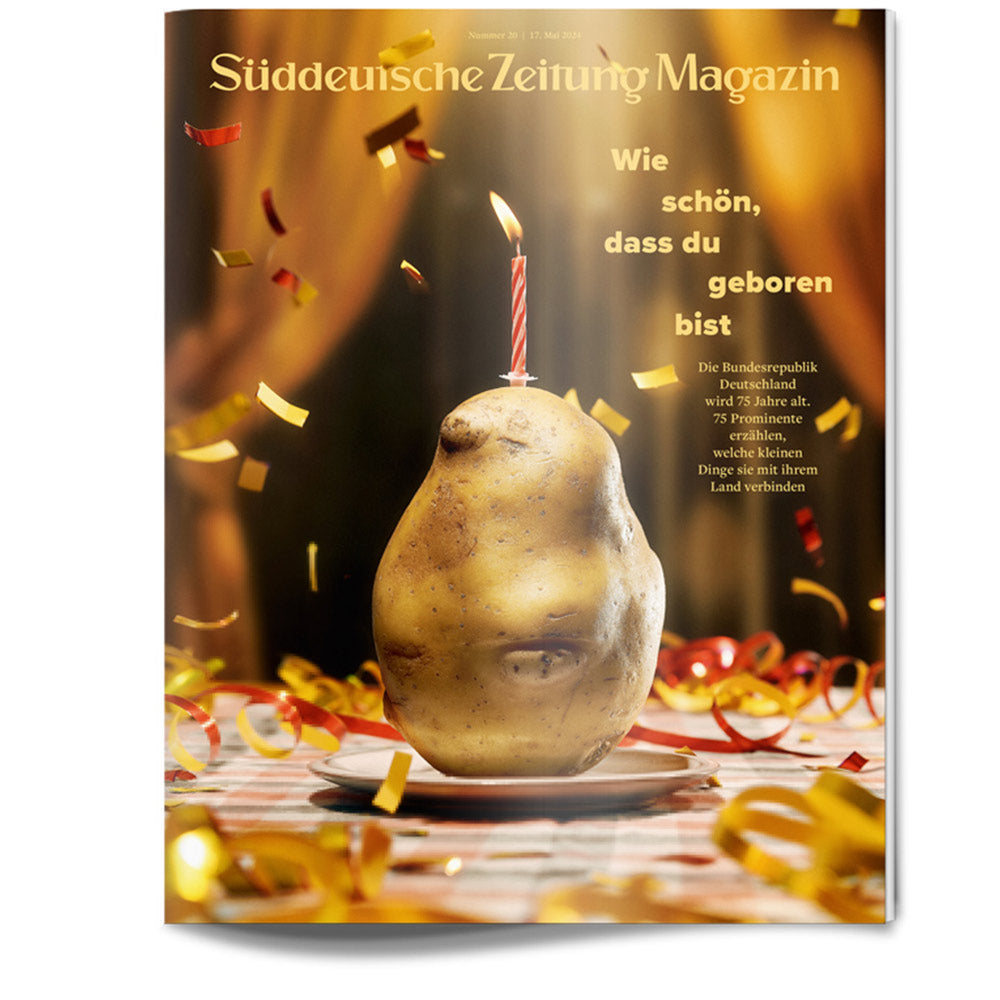 Eine Kartoffel mit einer brennenden Geburtstagskerze obenauf, umgeben von Konfetti und Schleife, auf einem Zeitschriftencover.