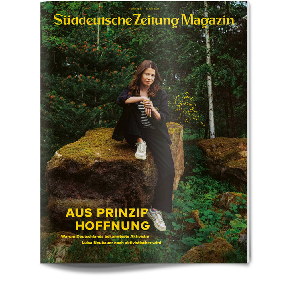 Auf dem Titelbild des Süddeutsche Zeitung Magazins sitzt eine Frau auf einem großen moosbewachsenen Felsen in einem Wald.