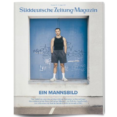 Auf dem Cover des Süddeutsche Zeitung Magazins steht ein Mann in Sportkleidung vor einer blauen, mit Graffiti beschmierten Wand.