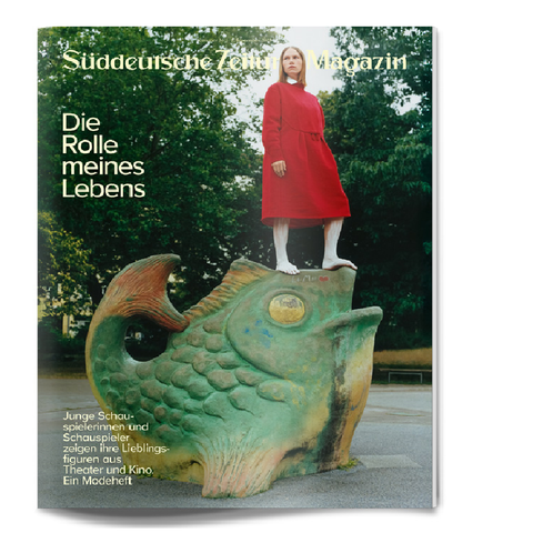 Eine Frau in einem roten Kleid steht auf einer großen Fischskulptur; Magazinumschlag mit deutschem Text.