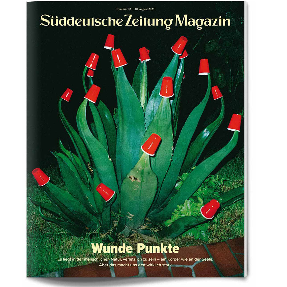 Eine Agavenpflanze mit roten Plastikbechern, die ihre Spitzen bedecken, auf einer Titelseite des Süddeutsche Zeitung Magazins.