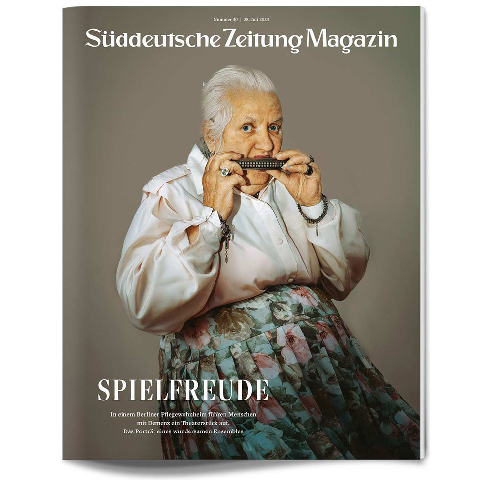 Eine ältere Frau im geblümten Rock spielt Mundharmonika auf dem Cover des Süddeutsche Zeitung Magazins.