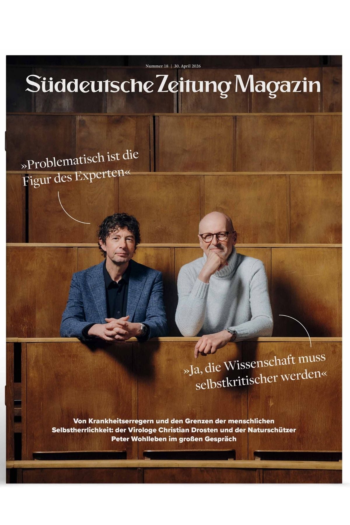 Zwei Männer sitzen auf hölzernen Hörsaalstühlen; ein Text auf Deutsch zitiert sie, wie sie über wissenschaftliche Expertise und Selbstkritik diskutieren. Das Titelbild stammt aus dem Süddeutsche Zeitung Magazin, April 2026.
