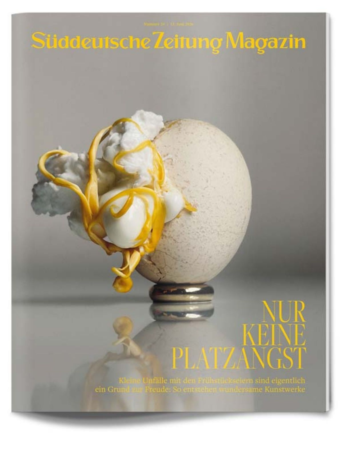 Ein aufgeschlagenes Ei steht aufrecht mit gelbem Eigelb und weißem Schaum, der überläuft, auf dem Cover des Süddeutsche Zeitung Magazins mit deutschem Text.