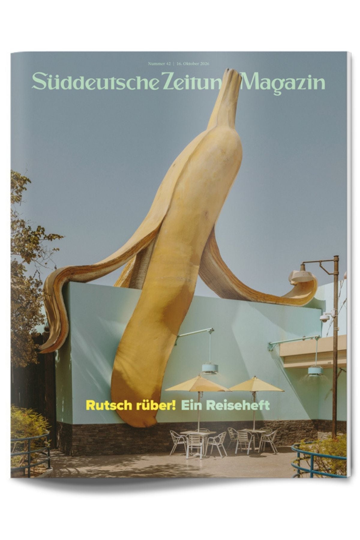 Titelseite einer Zeitschrift mit einer riesigen Bananenskulptur an einer Gebäudefassade, einem Straßencafé und dem Schriftzug Rutsch rüber! Ein Reiseheft.