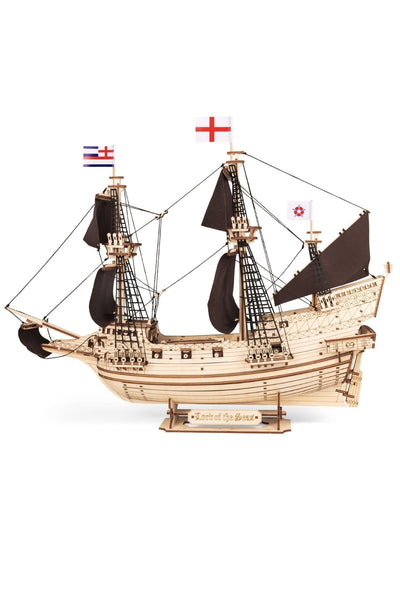 Ein hölzernes Schiffsmodell mit schwarzen Segeln, komplizierter Takelage und drei Flaggen, ausgestellt auf einem Ständer mit der Aufschrift Lord of the Seas.