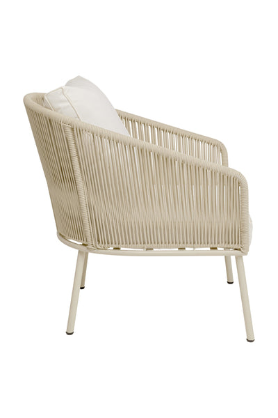 Ein beiger, moderner Loungesessel mit geflochtenem Seilrahmen, weißem Kissen und abgewinkelten Metallbeinen, dargestellt in der Seitenansicht.