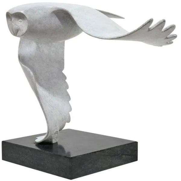 Skulptur einer stilisierten Eule im Flug, montiert auf einem schwarzen rechteckigen Sockel.