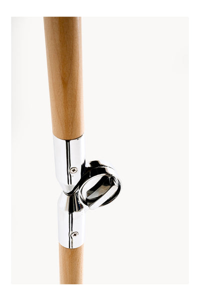 Nahaufnahme von zwei Holzstäben, die durch ein glänzendes Metallgelenk mit einem kreisförmigen Spannmechanismus verbunden sind, vor einem schlichten weißen Hintergrund.