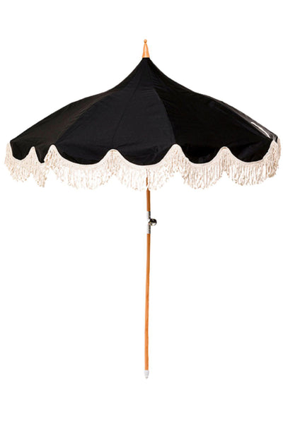 Ein schwarzer Regenschirm mit Holzstange und cremefarbenem Fransenbesatz am Rand.
