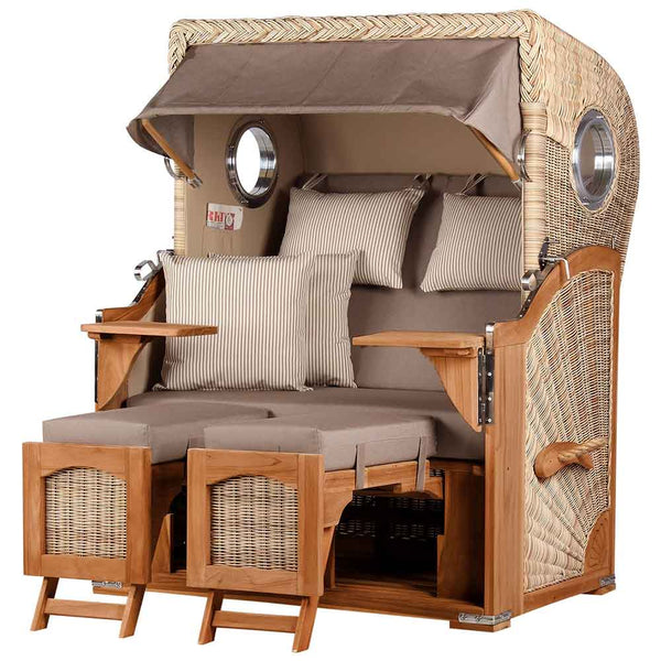 Ein Strandkorb mit Baldachin, gepolsterten Kissen, gestreiften Kissen, Armlehnen aus Holz, ausklappbaren Fußstützen und Bullaugen an den Seiten.