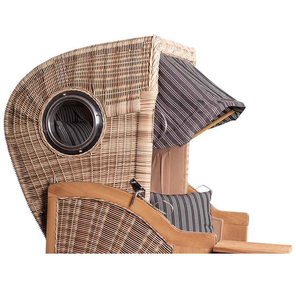 Ein Strandkorb mit abgerundeter Haube, gestreiften Polstern und einem eingebauten runden Fenster an der Seite.