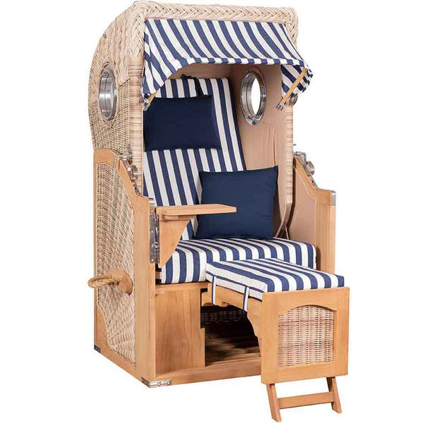 Ein Strandkorb mit Sonnendach, blau-weiß gestreiften Kissen, klappbaren Tischen, Fußstützen und seitlichen Griffen.