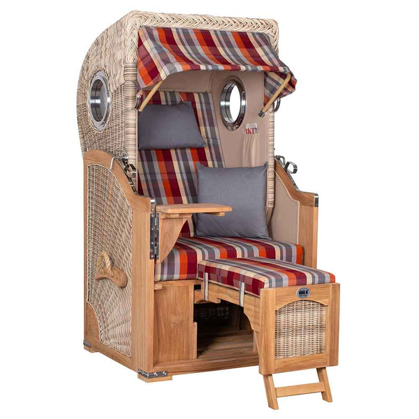 Ein Strandkorb mit Holzrahmen, gestreiften Kissen, einklappbaren Fußstützen, klappbaren Tischen und einem Baldachin, der für den Aufenthalt im Freien konzipiert ist.