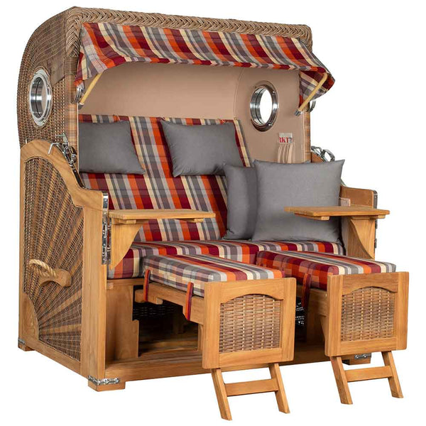 Ein zweisitziger Strandkorb mit Sonnendach, gestreiften Kissen, zwei ausziehbaren Fußstützen und kleinen Beistelltischen.