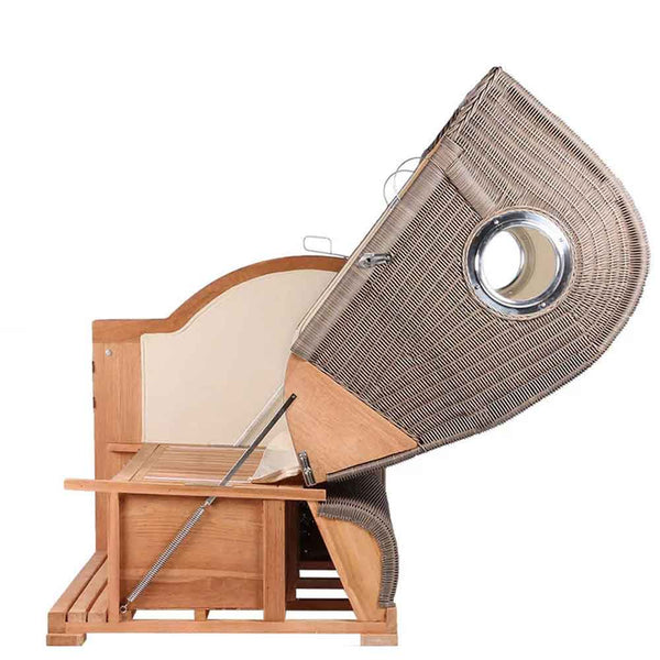 Liegestuhl aus Holz und Korbgeflecht mit eingebautem Sonnendach und rundem Seitenfenster, von der Seite gesehen.