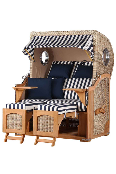 Ein Strandkorb mit marineblau-weiß gestreiftem Sonnendach, passenden Kissen, Holzgestell und integrierten Fußstützen.
