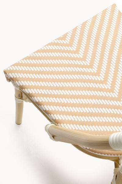 Nahaufnahme eines Stuhlsitzes mit beige-weißem Chevron-Webmuster, der einen Teil des gebogenen Holzrahmens und der Beine zeigt.