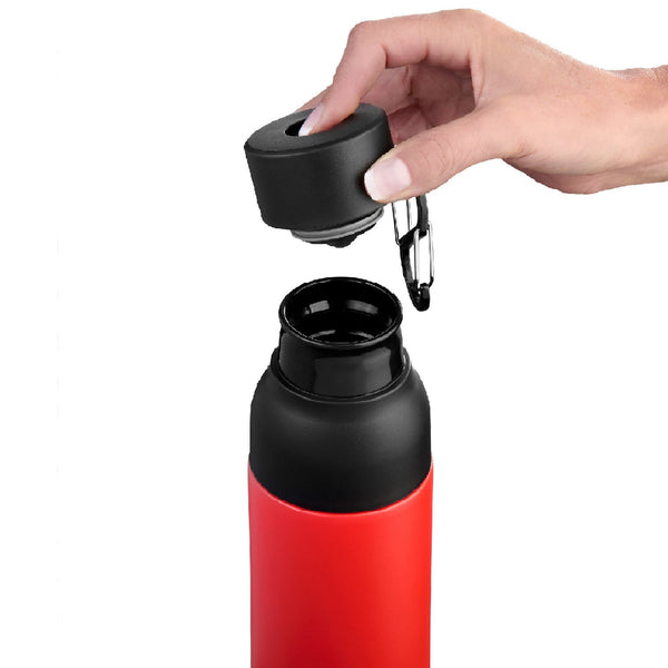 Eine Hand entfernt den schwarzen Deckel von einer roten wiederverwendbaren Wasserflasche vor einem schlichten Hintergrund.