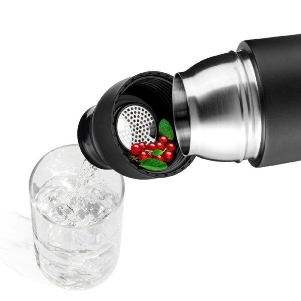 Eine schwarze Thermoskanne mit einem Sieb gießt klare Flüssigkeit in ein Glas; das Sieb enthält rote Beeren und grüne Blätter.