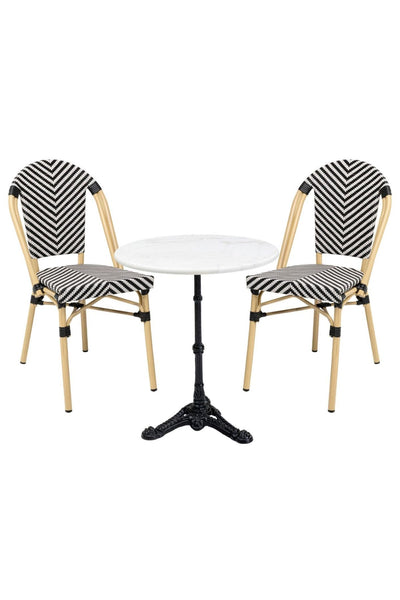 Zwei schwarz-weiße Stühle mit Chevron-Muster und hellem Holzgestell flankieren einen kleinen runden Tisch mit weißer Marmorplatte und schwarzem, verschnörkeltem Metallsockel.