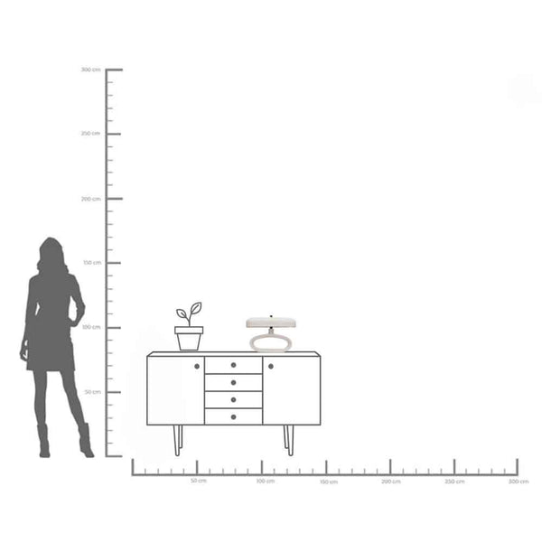 Eine maßstabsgetreue Illustration, die die Silhouette einer Person neben einem Sideboard mit einer Pflanze und Dekoration darauf zeigt, mit Höhen- und Breitenangaben in Zentimetern.