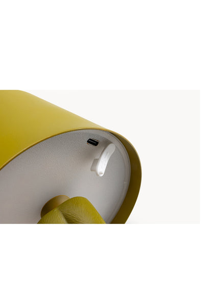 Nahaufnahme der Unterseite eines gelben Geräts mit einem USB-C-Ladeanschluss und einem Ein/Aus-Schalter.