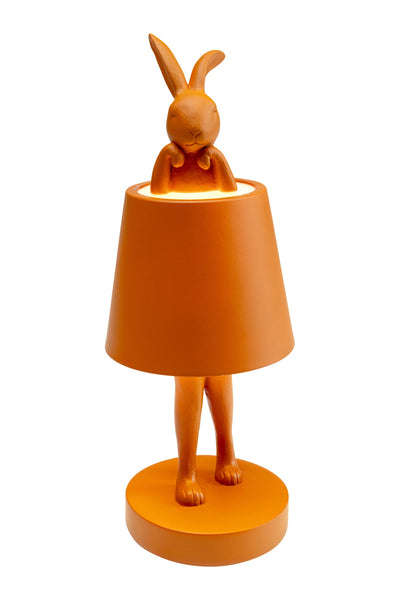 Eine orangefarbene Lampe in Form eines Kaninchens, wobei der Lampenschirm den Körper bedeckt und Kopf und Füße des Kaninchens sichtbar sind.