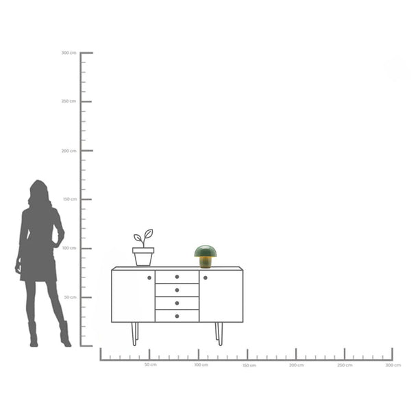 Silhouette einer Frau neben einer Anrichte mit einer Pflanze und einer Lampe, dargestellt in einem metrischen Höhen- und Breitenmaßstab.