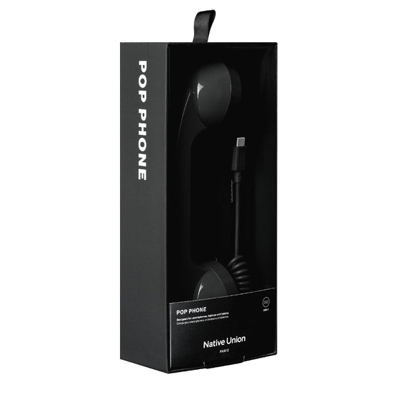 Eine schwarze Verpackung des Native Union Pop Phone mit einem Hörer im Retro-Stil, dessen Kabel und Stecker durch ein durchsichtiges Fenster sichtbar sind.