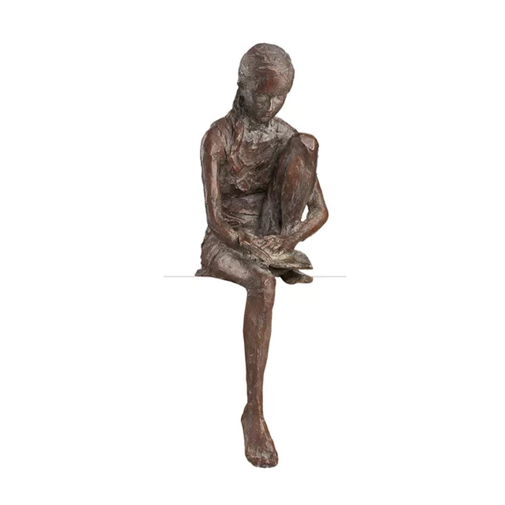 Die Bronzeskulptur „Lesende“ von Valerie Otte stellt ein sitzendes, lesendes Mädchen mit angehobenem Knie dar, ohne Eichensockel.