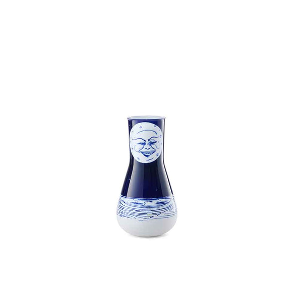 Blau-weiße Vase mit einem lächelnden Mondgesicht und einem Wellenmuster auf weißem Hintergrund.