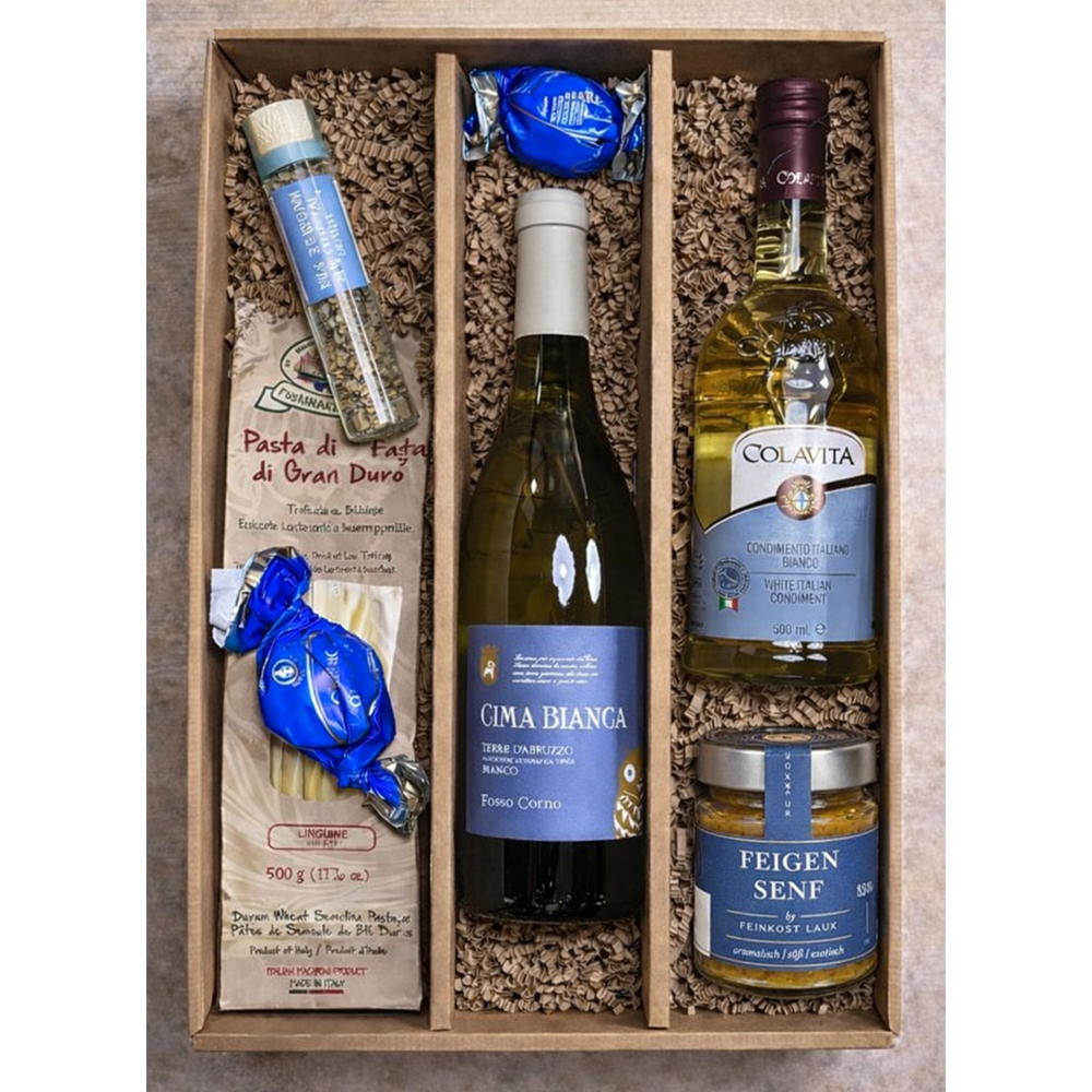 Eine Geschenkbox mit Nudeln, Weißwein, Olivenöl, Senf, Kräutern und zwei verpackten Pralinen.