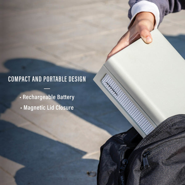 Eine Person legt ein kompaktes, tragbares elektronisches Gerät mit Braillezeile in eine schwarze Reißverschlusstasche; der Text hebt den wiederaufladbaren Akku und den magnetischen Deckelverschluss hervor.