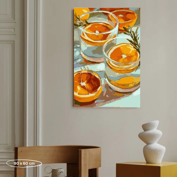 Gemälde mit Orangenscheiben und Rosmarin in Gläsern an einer Wand über einem Holzstuhl und einem Tisch mit weißen Vasen.